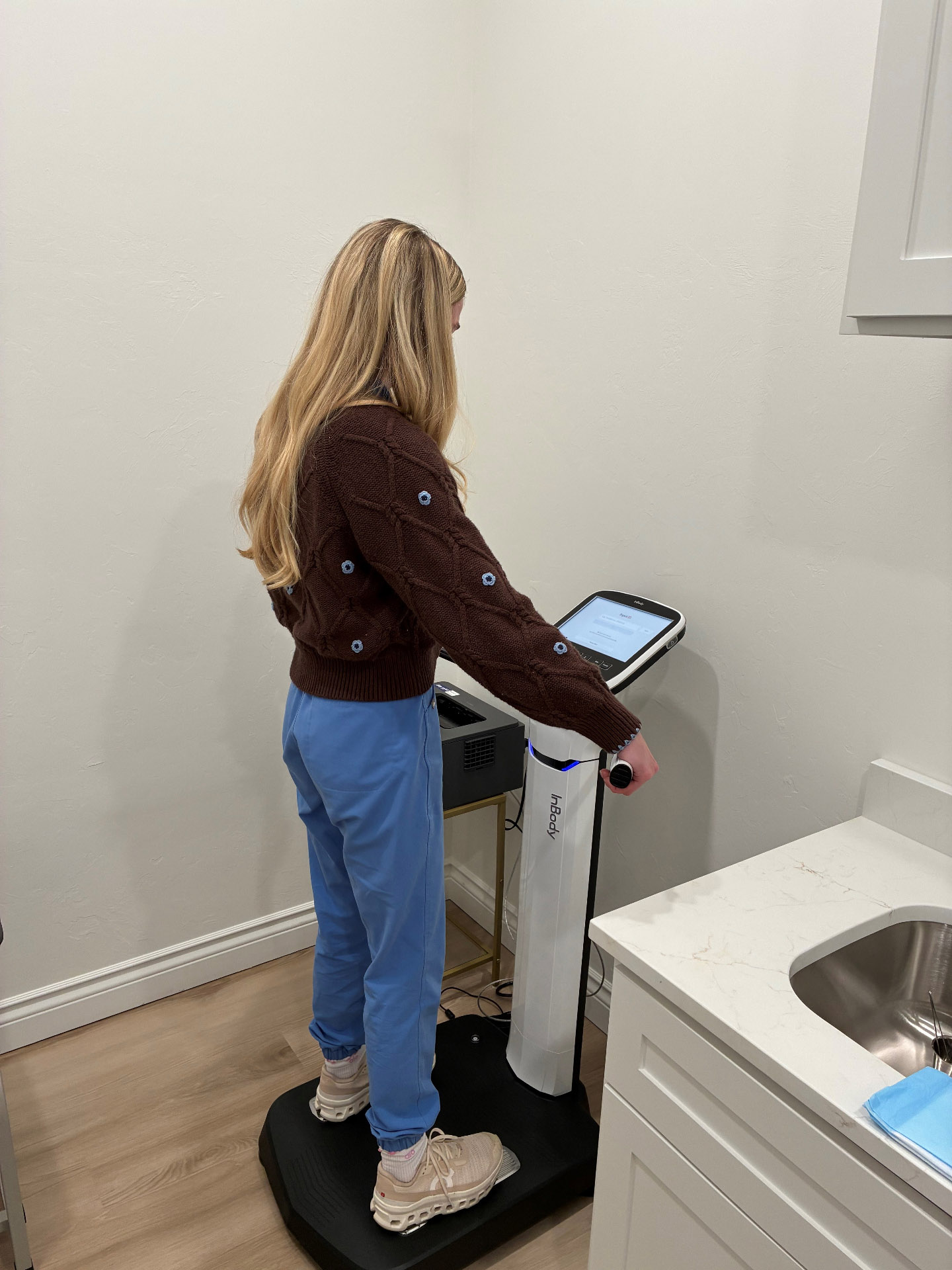 A patient standing on the InBody body-composition scanner during a quick scan at Pristine Health